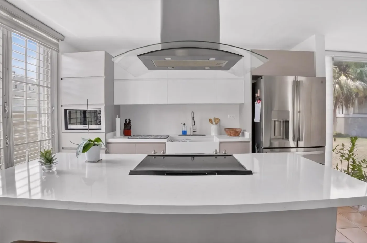 Cocina moderna con isla, campana y electrodomésticos de acero inoxidable