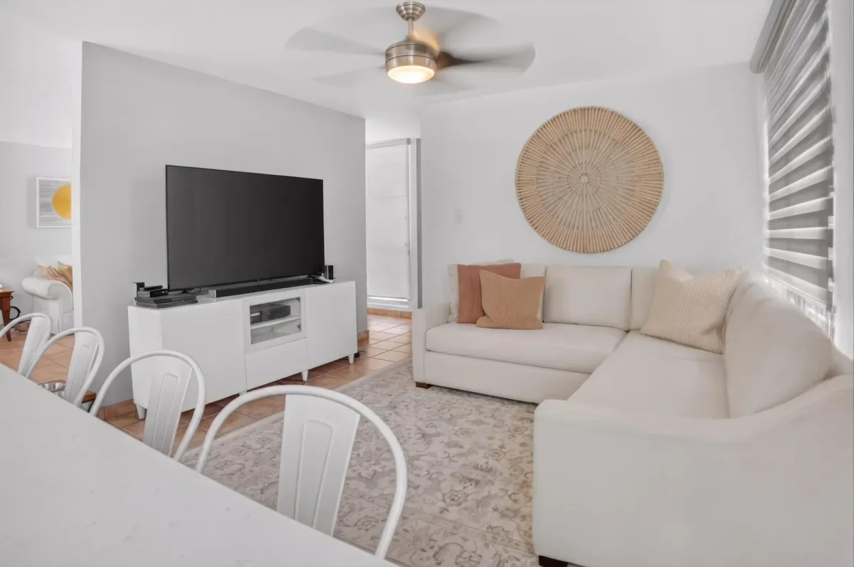 Sala de estar con televisor y sofá seccional, decoración neutral