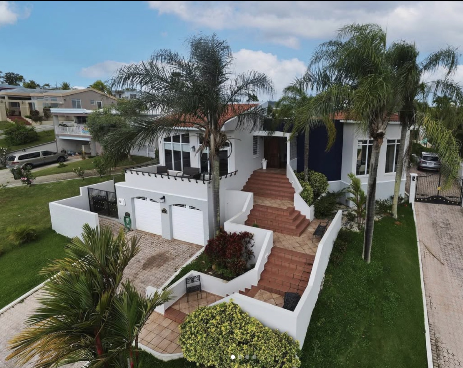 Vista aérea de residencia de lujo con palmeras y techo de teja en Puerto Rico