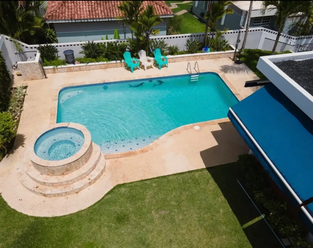 Vista aérea de una piscina turquesa con jacuzzi en una propiedad en Puerto Rico